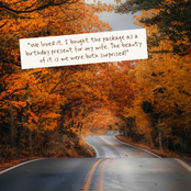 A scenic autumn road lined with bright orange and yellow foliage, with a white text overlay card that reads: “We loved it. I bought the package as a birthday present for my wife.