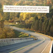 A winding country road through autumn forest with trees in yellow, green, and orange tones. A white text box near the top reads, “Saw places in our own area we had never seen before.