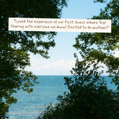 A scenic photograph of a blue sea and sky framed by green tree leaves, with a white text banner overlay that reads: 'Loved the experience of our First Guess Where Trip! Sharing with everyone we know! Excited to do another!'.