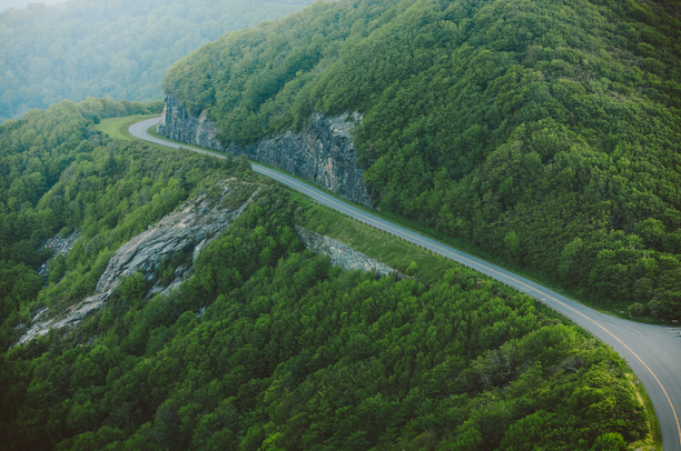 Green forested mountains with a road winding through.