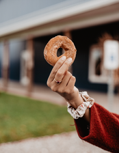 Hand holding up a donut from a bakery