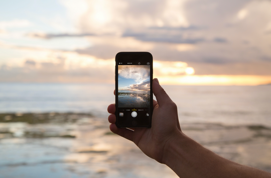 Photo of an iPhone screen showing a photo of the beach.