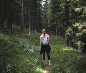 Girl standing away from the camera in the middle of a forest