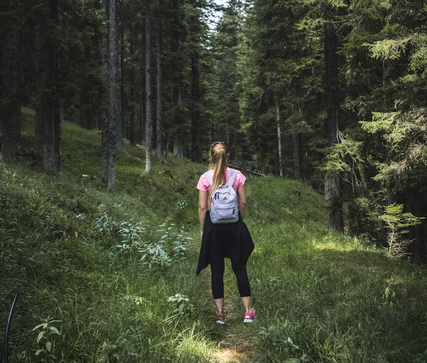 Girl standing away from the camera in the middle of a forest