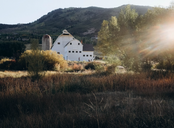 White farm house in front of a mountain