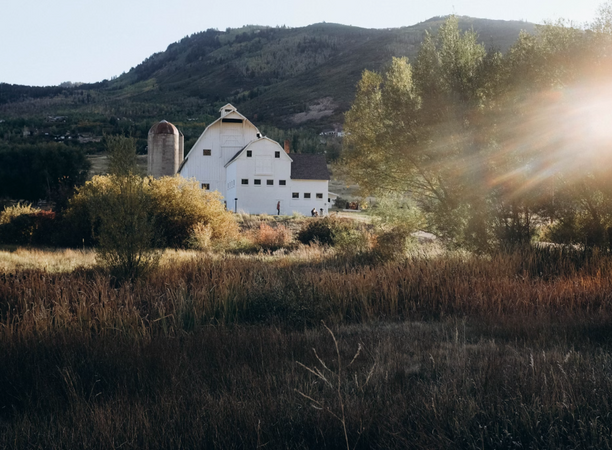 White farm house in front of a mountain