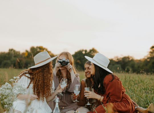 Group of friends sharing wine in a field
