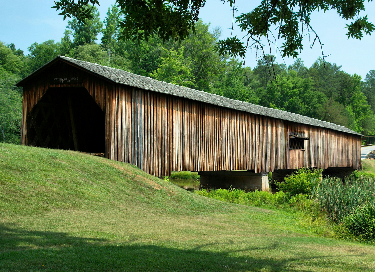 Wooden covered bridge overlooking green valley