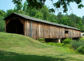Wooden covered bridge overlooking green valley