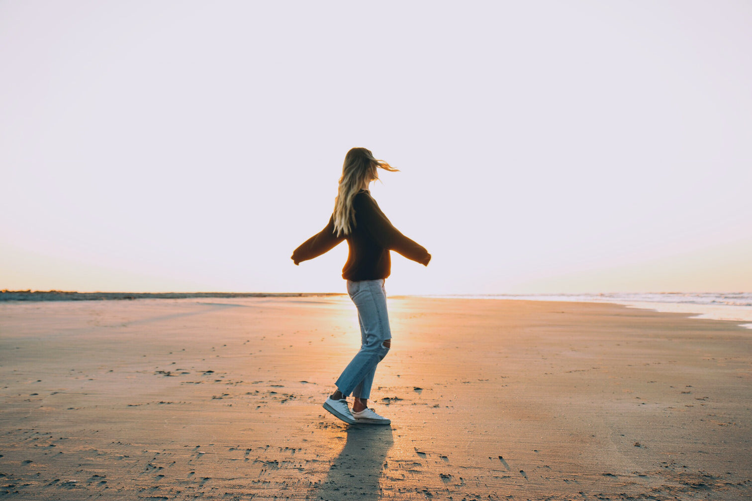 Woman spinning on the beach.