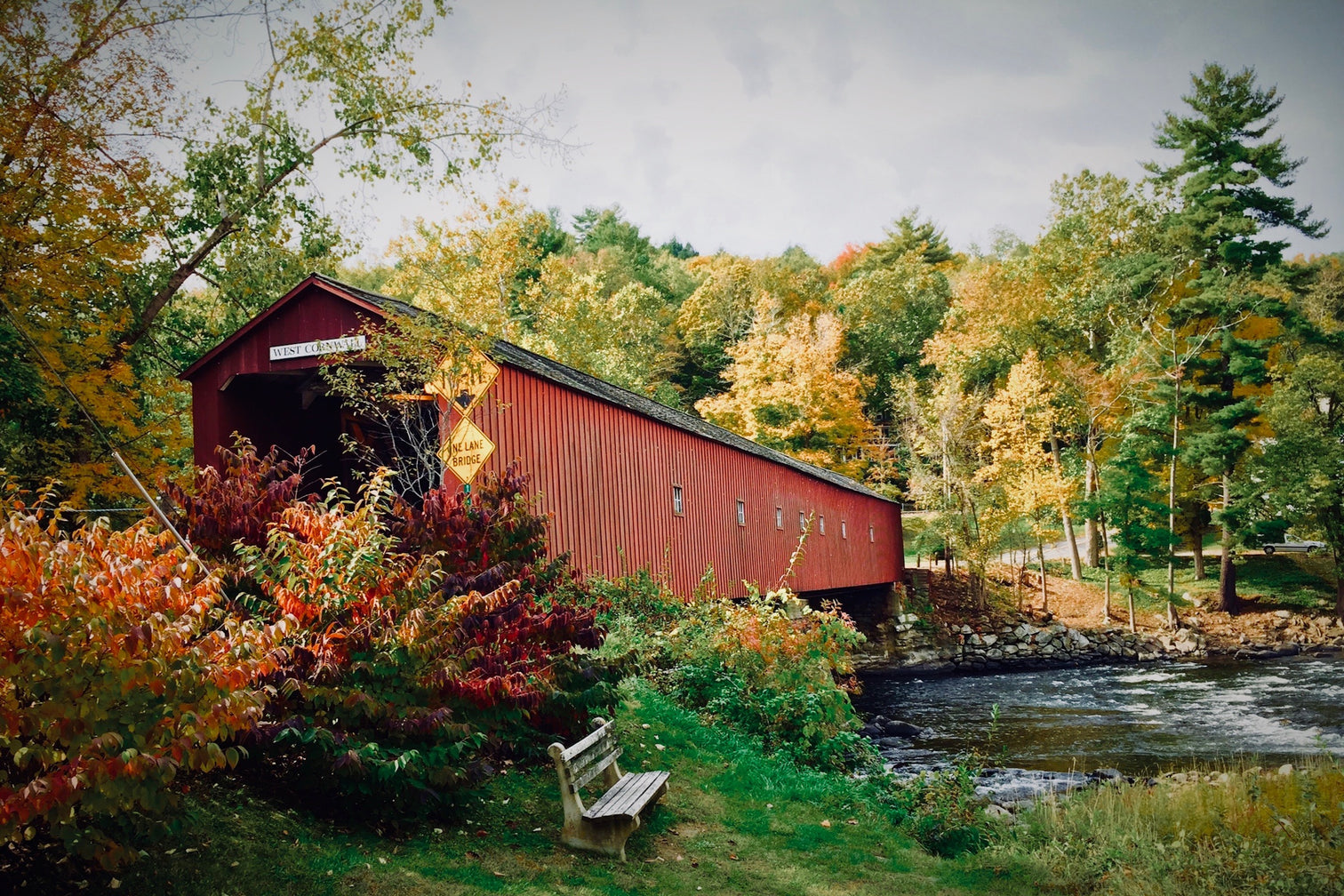Red covered bridge over water.