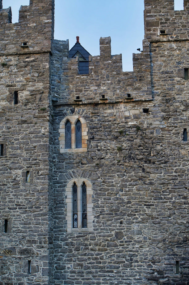 Medieval castle-like stone structure with a clear blue sky in the background.