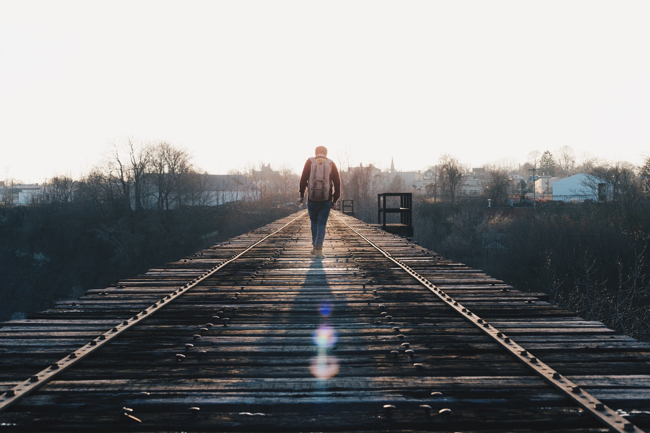 Man walking along railway.