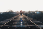 Man walking along railway.