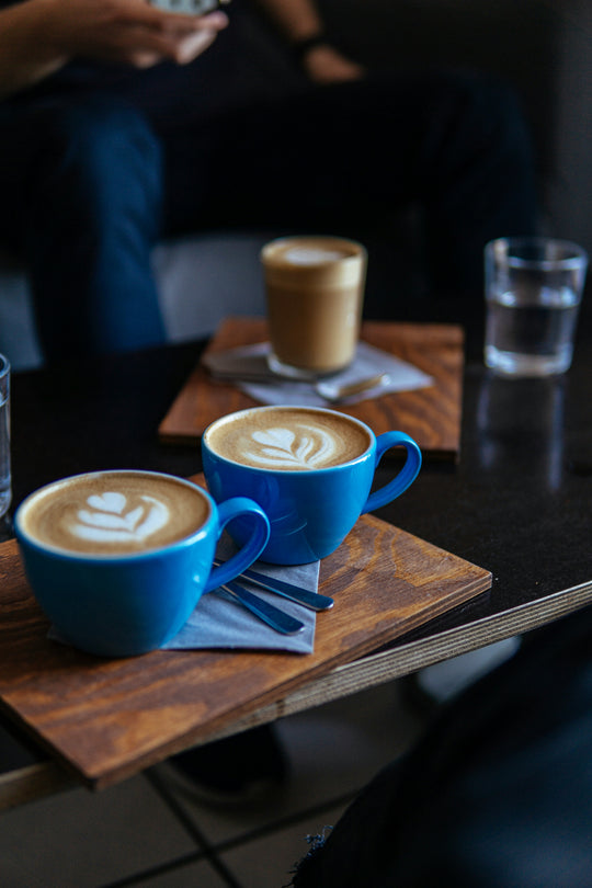 Two cappuccinos on a table in cafe