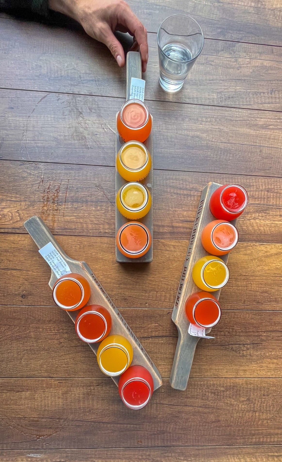 Colourful flights of beer on a wooden table at a brewery.