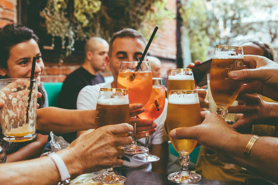 Group of people raising glasses to cheers.