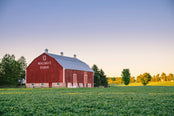 Red barn labeled 'Walnut Farm' in a field with trees and clear sky