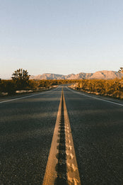 Road leading into desert with mountains ahead