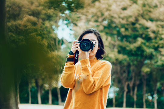 Woman taking a photo with a Canon camera.