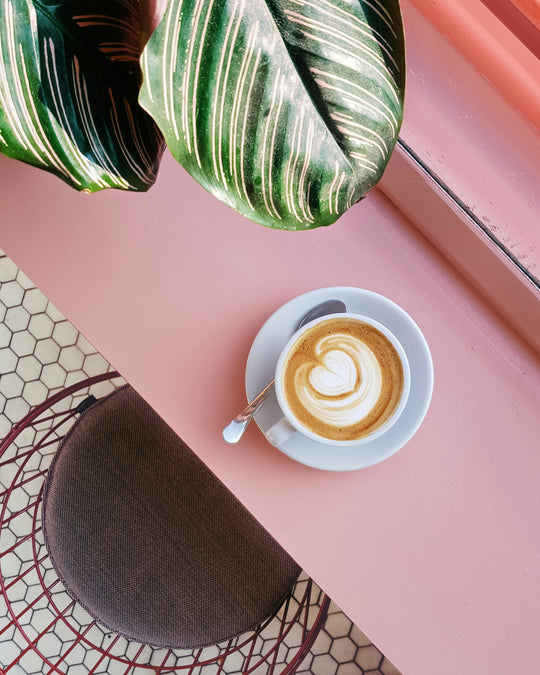 Latte on a pink table.