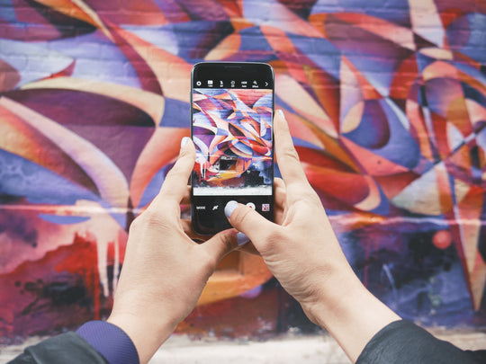 Photo of a photo of a mural being taken on a phone.