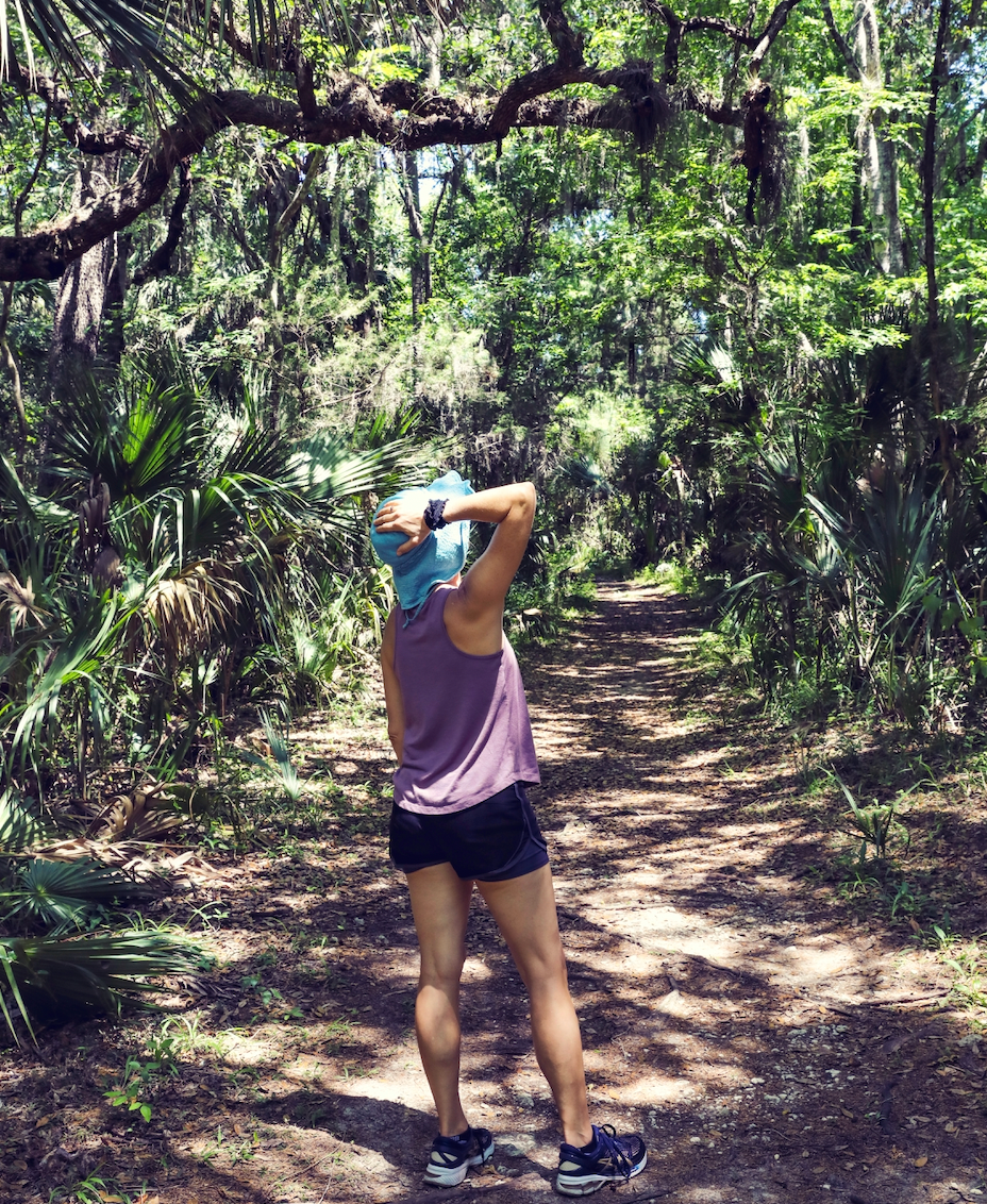 A person standing on a trail in a forested area