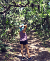 A person standing on a trail in a forested area