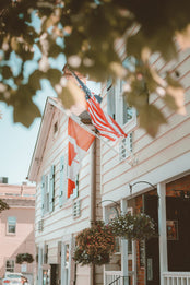 Historic building with American and Canadian flags hanging above.
