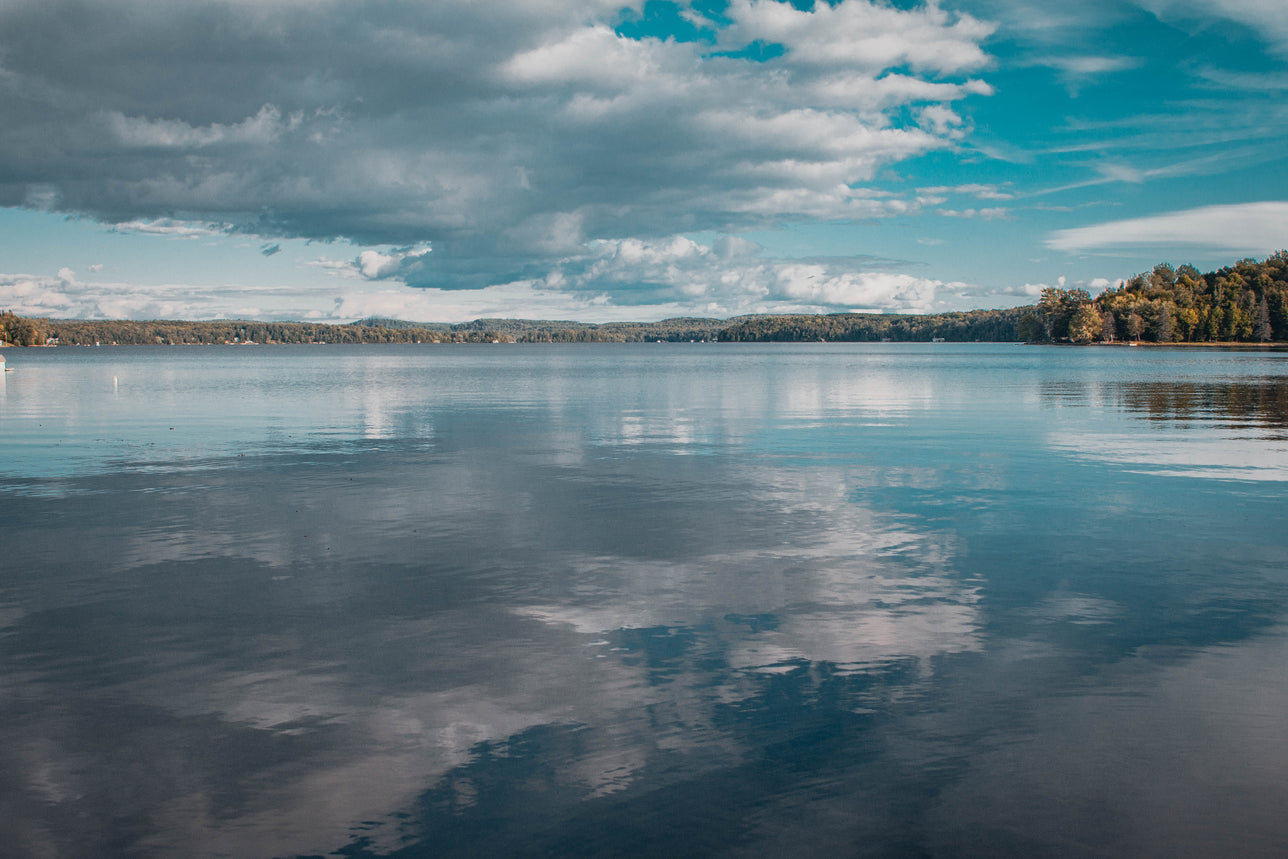 Lake reflecting blue sky and fluffy clounds