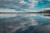 Lake reflecting blue sky and fluffy clounds