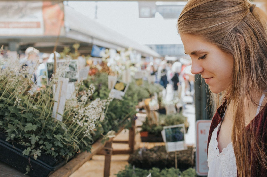 Woman looking at plants at a market.